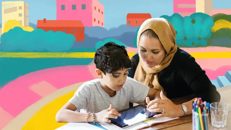 A mother in a headscarf helping her son with a tablet at the table